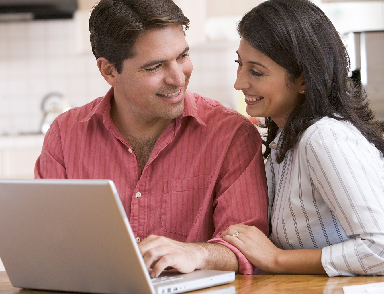 photo of a young couple sitting at laptop
